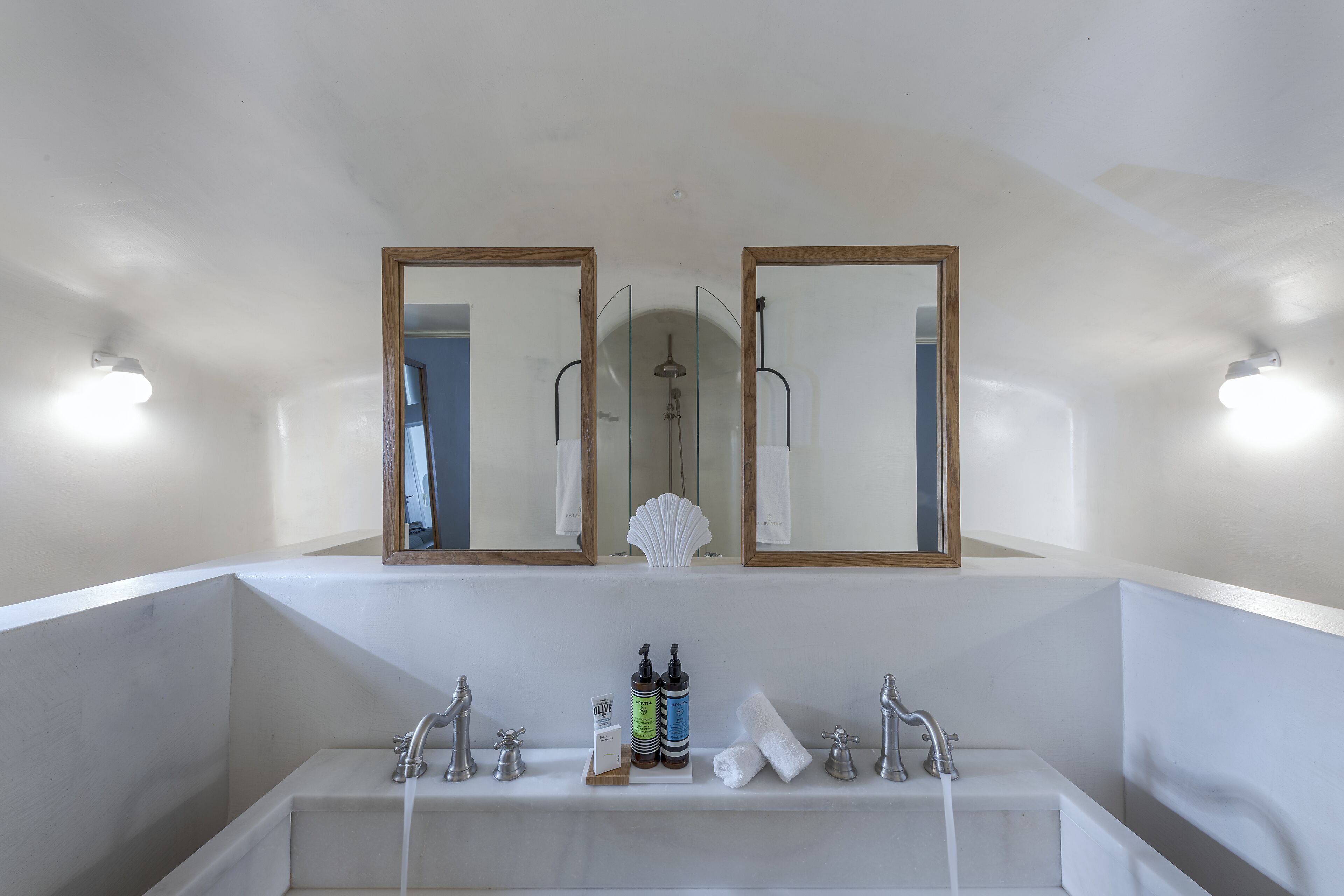Un bagno con una vasca da bagno ampia, due specchi e una doccia.