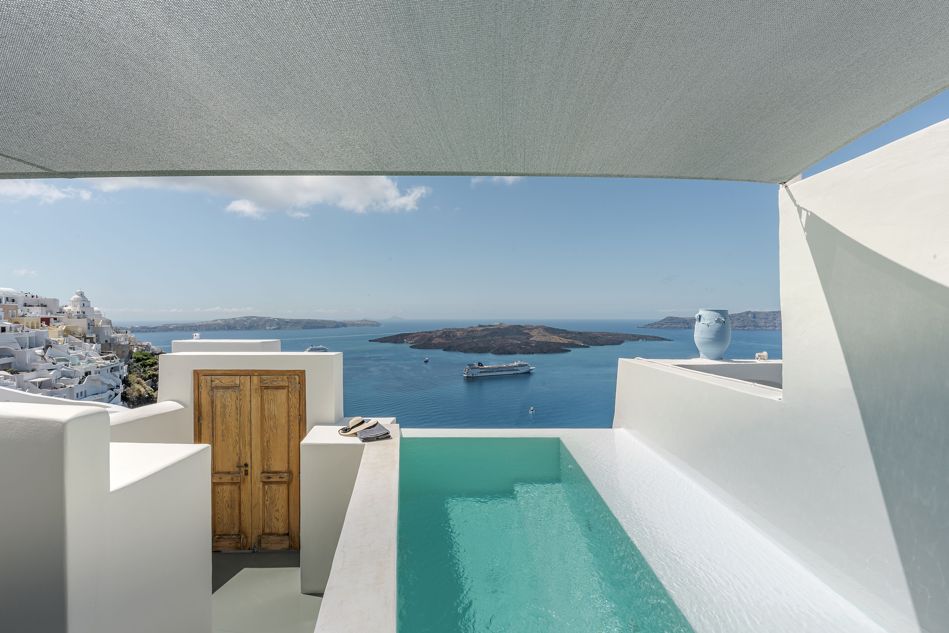 A rooftop pool with a view of a coastal town and the sea.