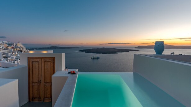 A rooftop terrace with a view of the sea and a sunset. - Thera Villas (Santorini)