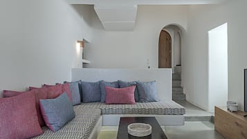 Ein modernes Wohnzimmer mit einem Ecksofa, einem Couchtisch und einer Treppe, die zu einer oberen Ebene führt.