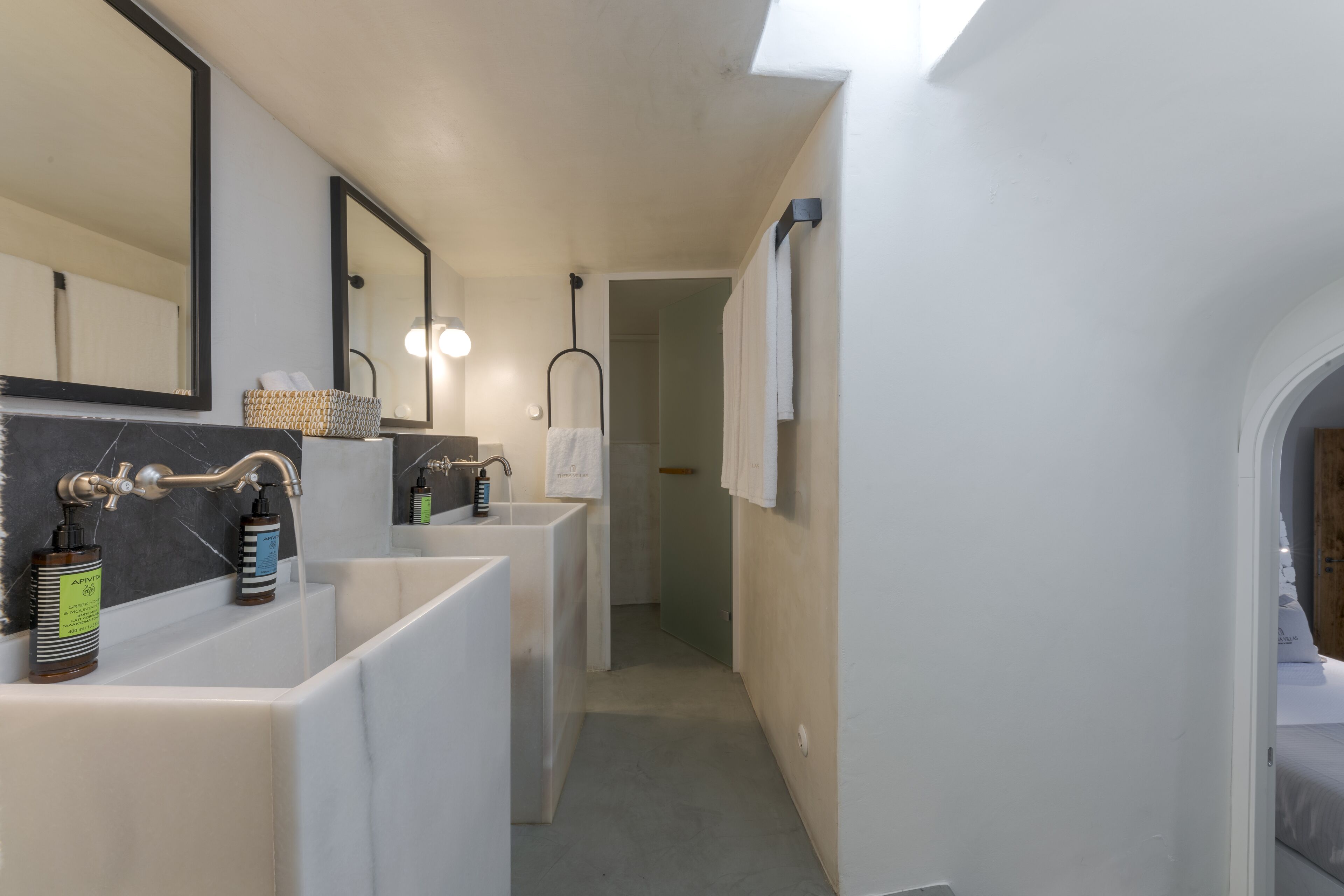 Un baño moderno con dos lavamanos, un espejo grande y zona de ducha.