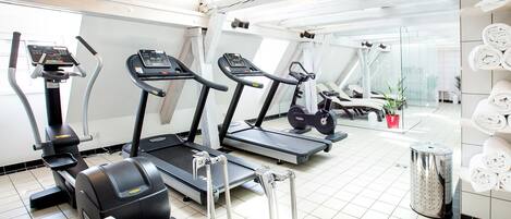 A gym with treadmills, a stationary bike, and a rowing machine.