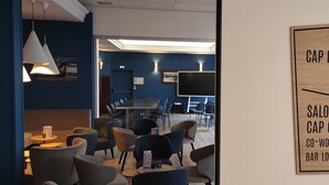 A modern lounge area with seating and a wooden sign indicating different meeting areas. - Hôtel Villa Des 2 Caps (Wimereux)