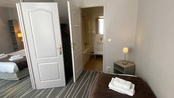 Una habitación de hotel con cama, baño y pasillo.