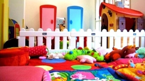 A child's playroom with a white picket fence, two doors, and various toys. - Hotel Villa Lina (Riccione)