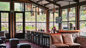 A bar area with stools, a counter, and a stone wall.