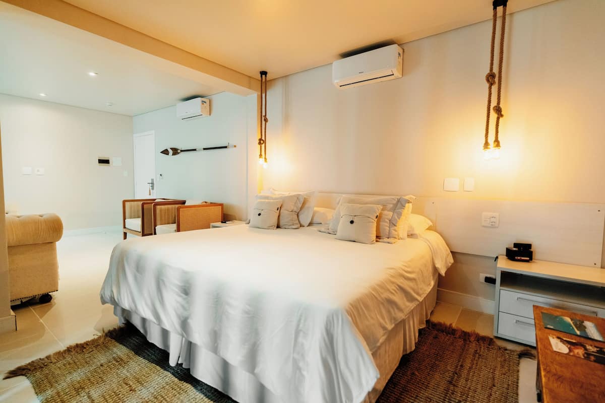 A modern hotel room with a large bed, bedside tables, a desk, and a chair.