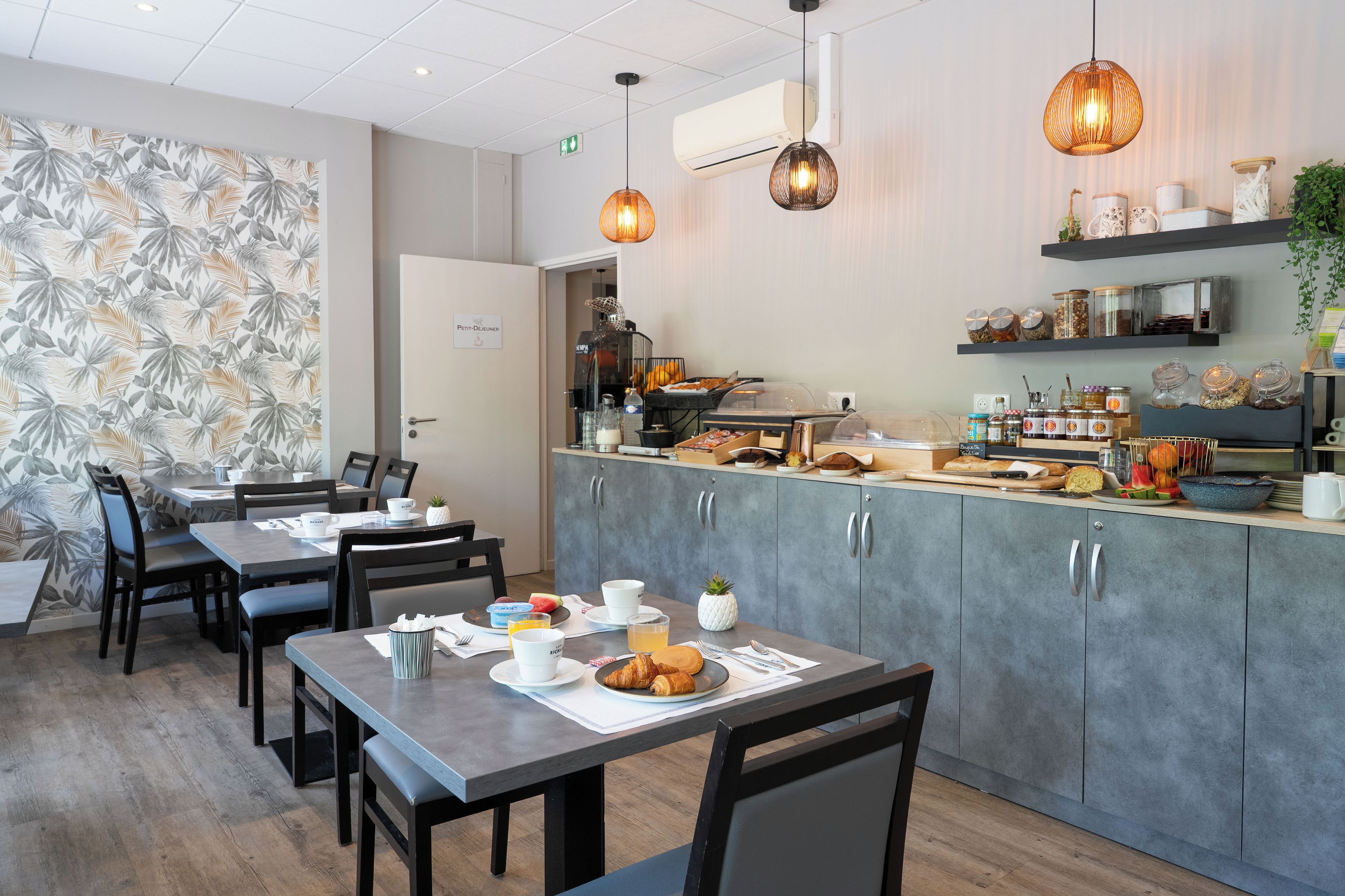 Un restaurant doté d’un comptoir, d’une salle où l’on peut s’asseoir et d’une cuisine.