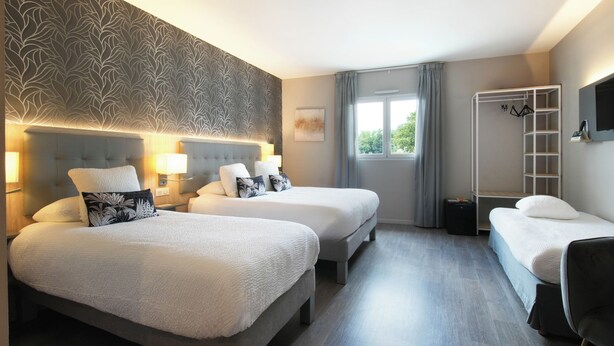 A hotel room with two beds, a wardrobe, a mirror, and a window with curtains. - Hôtel l'Amandier (Morlaas)