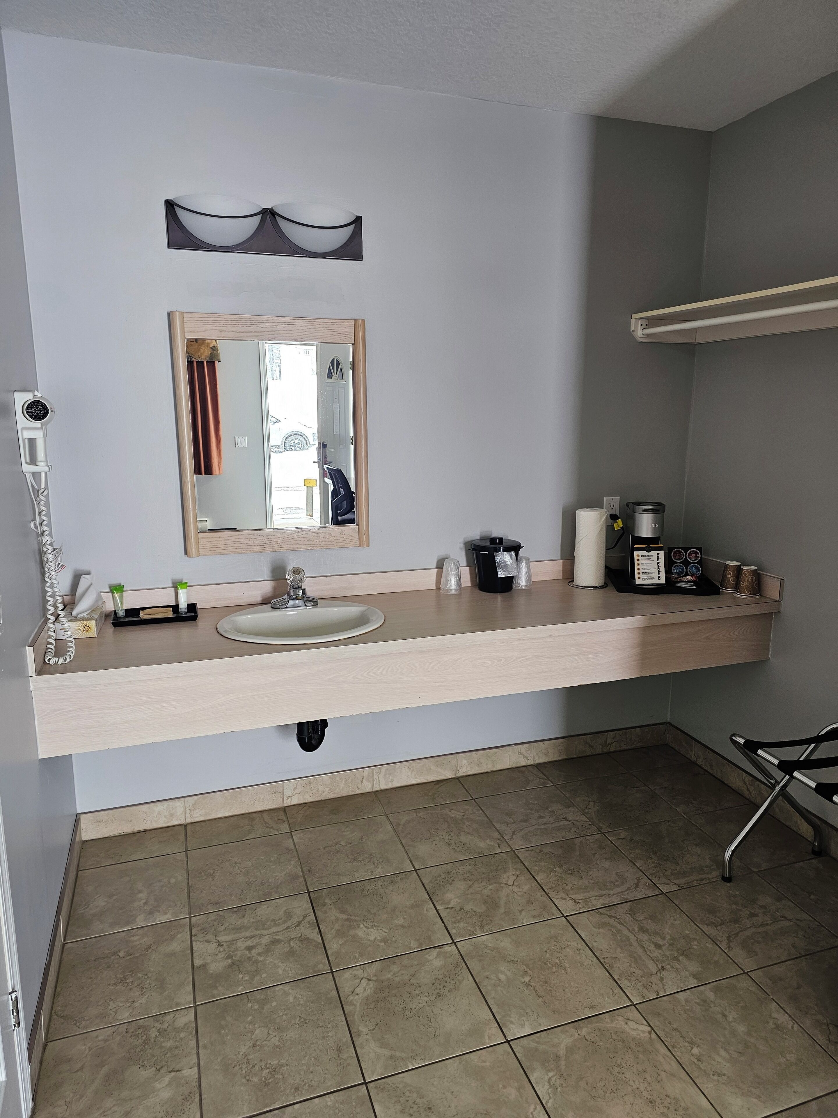 Une salle de bain équipée d’un lavabo, d’un miroir, d’un porte-serviettes et d’un espace douche.