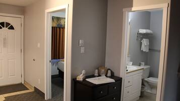 A hotel bathroom with a white sink, dark wooden vanity, and a toilet.