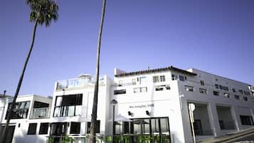 Un edificio moderno con fachada blanca, varias ventanas y un balcón.