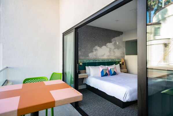 Una habitación de hotel moderna con una cama, una mesita y sillas.