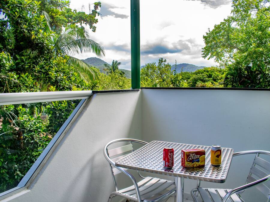 A balcony with a metal table and chairs, a Coca-Cola can, and a box of Ben & Jerry's ice cream.