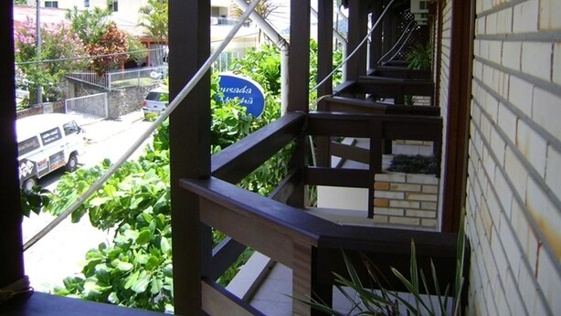 Una escalera de madera con vistas a una calle y vegetación.