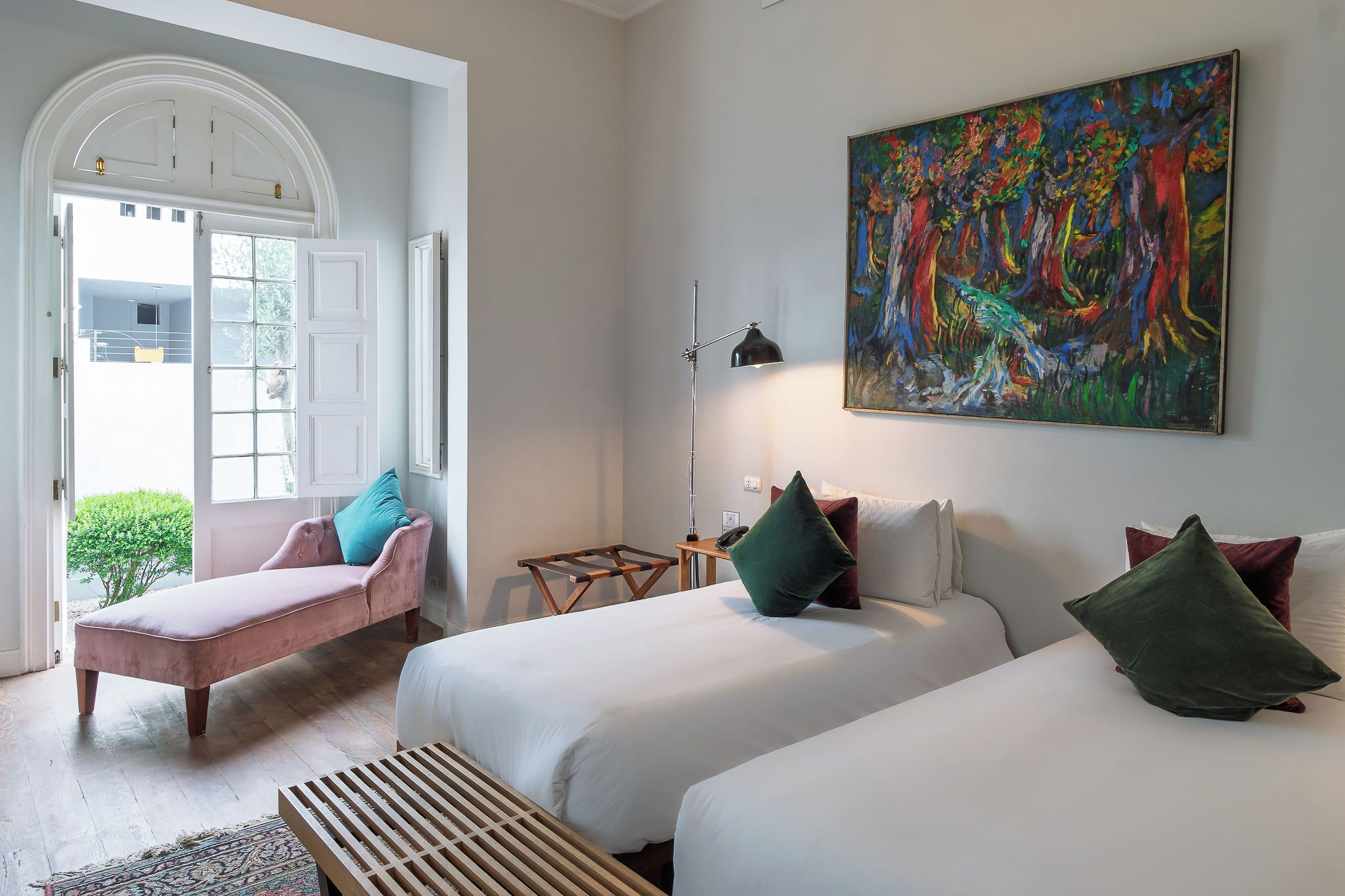 Habitació d'hotel amb un llit, una cadira, un escriptori i un quadre a la paret.