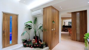 Un couloir avec des portes en bois, une plante en pot et une petite décoration de Noël.