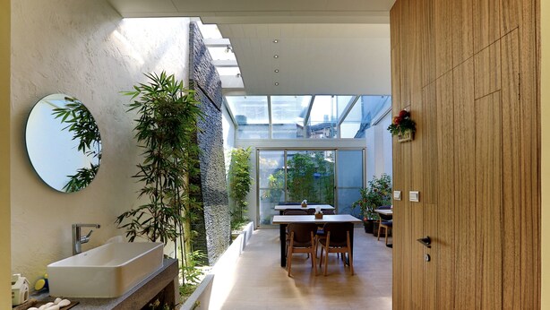 Une salle de bain moderne avec un grand miroir, un lavabo intégré et un jardin vertical.