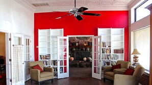 Un salon avec deux fauteuils, une bibliothèque et une cheminée.