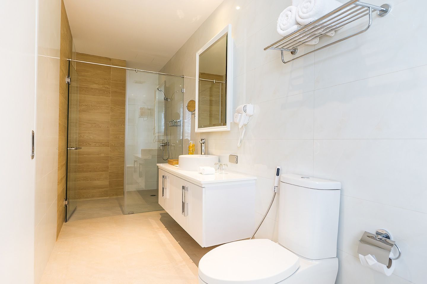 A modern bathroom with a glass-enclosed shower, a white sink, and a toilet.