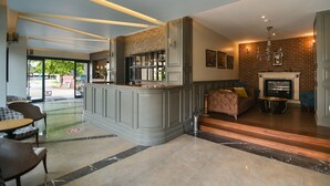 A lobby with a bar area, seating, a fireplace, and a view of the outdoors. - Seymen Hotel (Amasra)