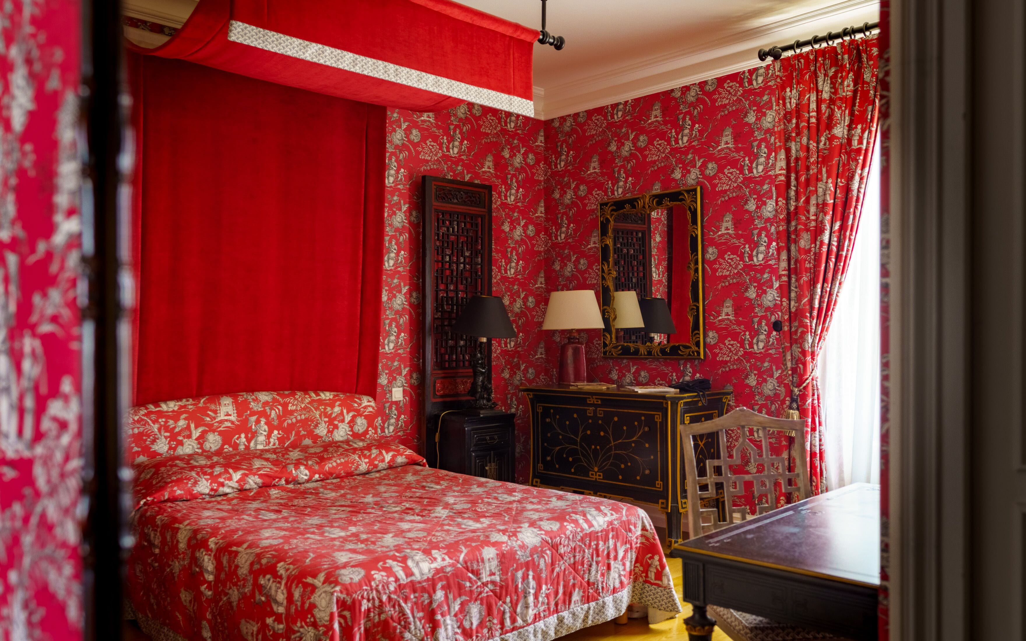 A room with a large bed, a nightstand, a dresser, and a mirror.