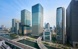 A modern cityscape with high-rise buildings, a river, and a bridge.