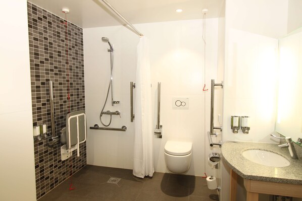Un baño moderno con ducha, inodoro y lavamanos.