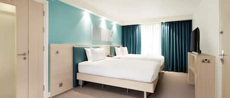 Habitación de hotel con una cama grande, un escritorio, un armario y una televisión.
