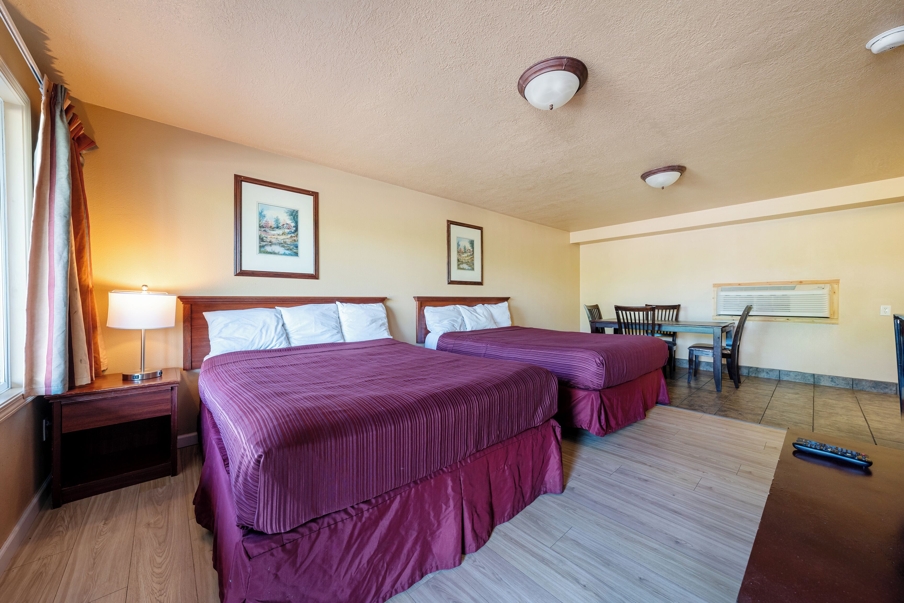 Habitación de hotel con dos camas, un escritorio y una silla.