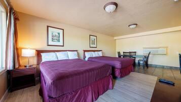 Habitación de hotel con dos camas, un escritorio y una silla.