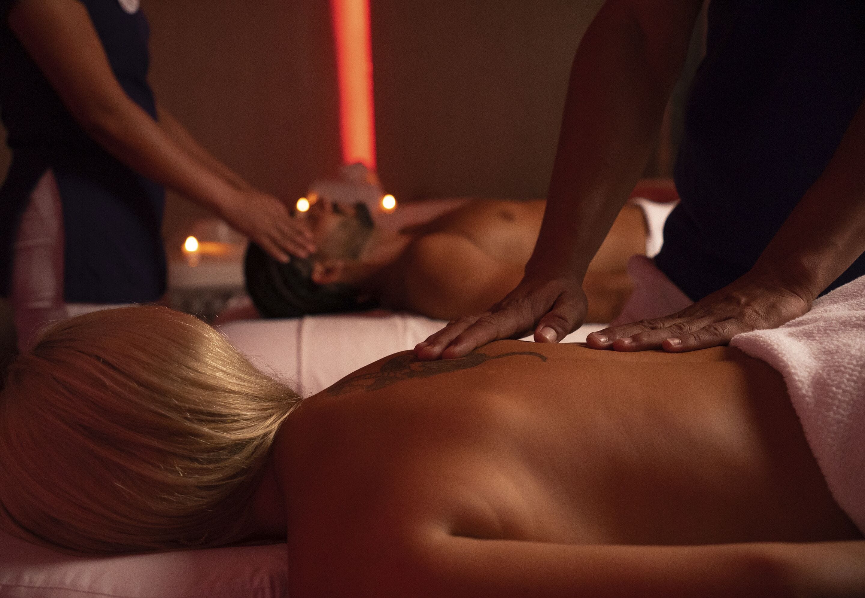 A massage therapy session in a dimly lit room with candles.