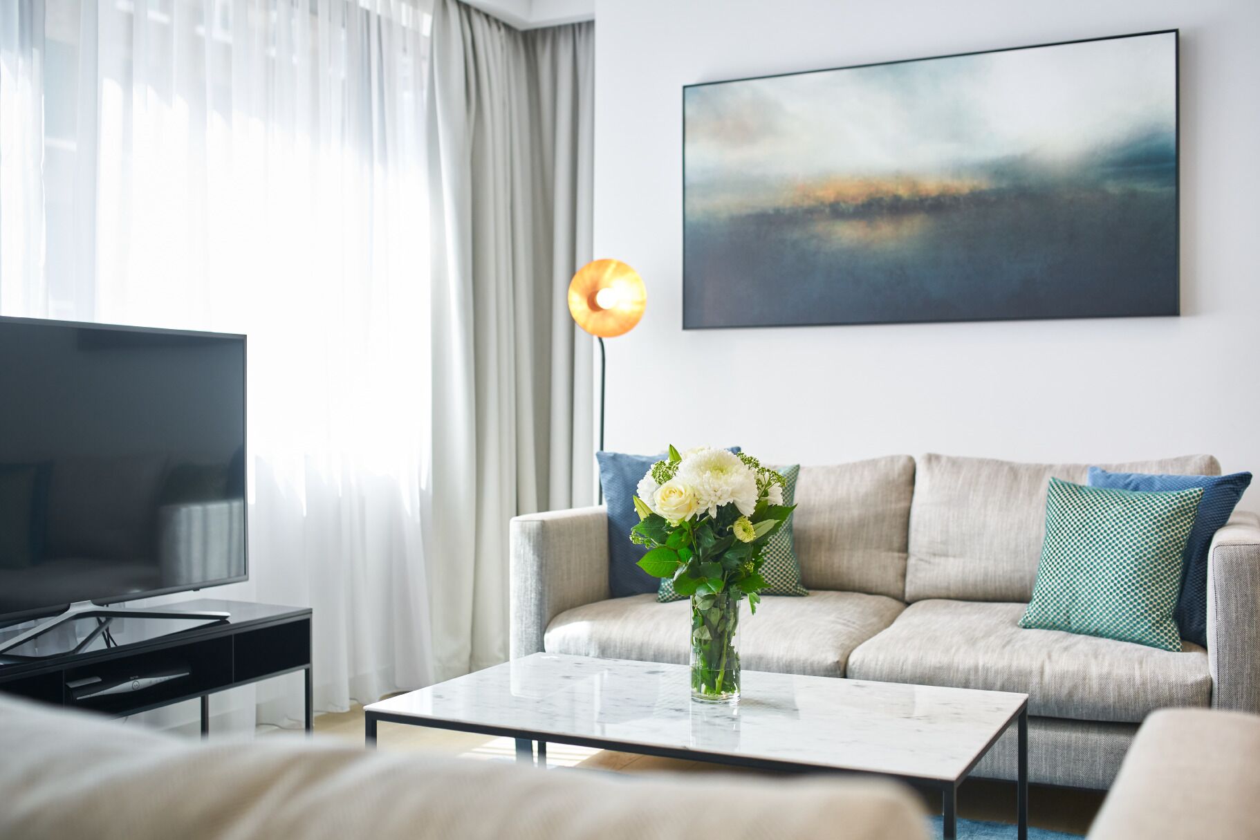 Una sala de estar moderna con un sofá, una mesa de centro y un televisor.