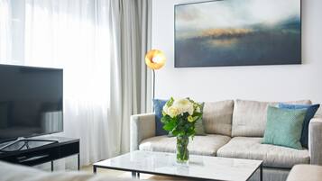 Una sala de estar moderna con un sofá, una mesa de centro y un televisor.