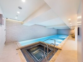 Una piscina techada, sillones reclinables de piscina