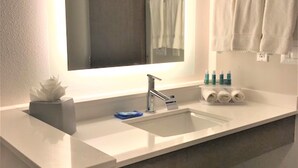 A modern bathroom with a large mirror, two sinks, and a towel rack. - Holiday Inn Express & Suites Houston SW - Galleria Area by IHG (Houston)