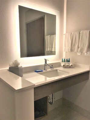 A modern bathroom with a large mirror, two sinks, and a towel rack. - Holiday Inn Express & Suites Houston SW - Galleria Area by IHG (Houston)