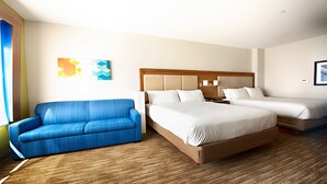 A hotel room with a large bed, a blue sofa, and a wooden floor. - Holiday Inn Express & Suites Houston SW - Galleria Area by IHG (Houston)