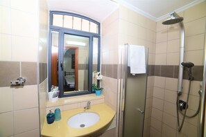 Un baño con lavamanos, espejo y ducha.