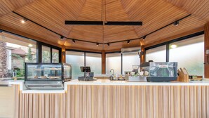 Un comptoir de cuisine moderne, équipé d’une machine à café, d’une vitrine et d’un moulin à café.