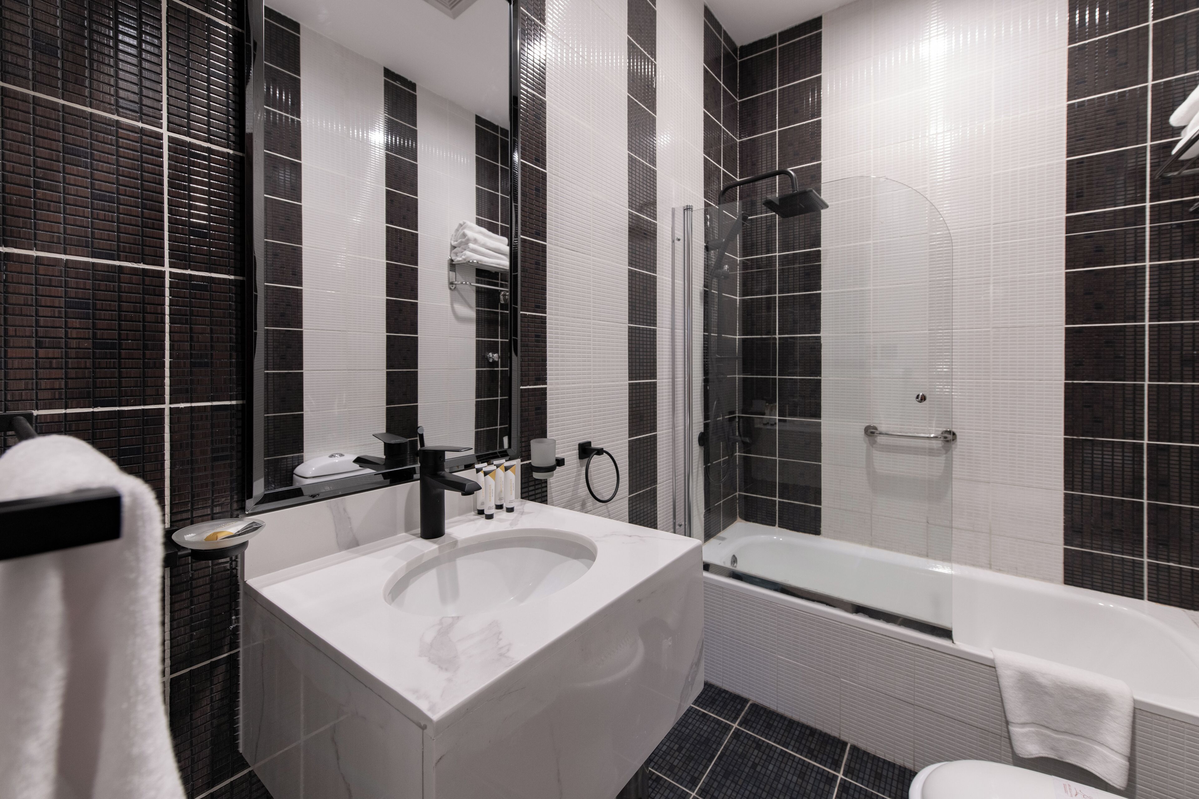 A modern bathroom with a large sink, a bathtub, and a glass shower enclosure.