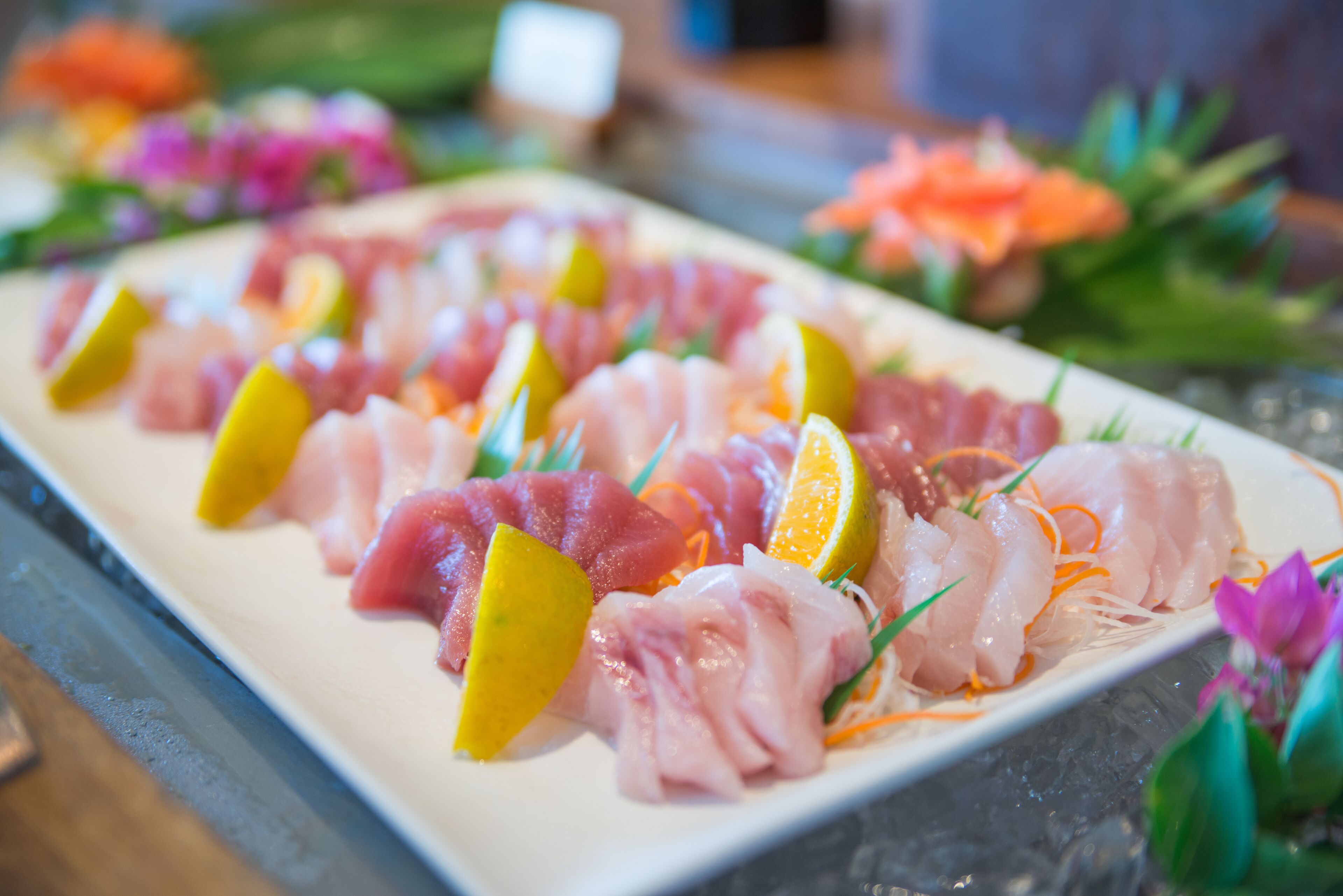 A sushi platter with various types of fish and garnishes.