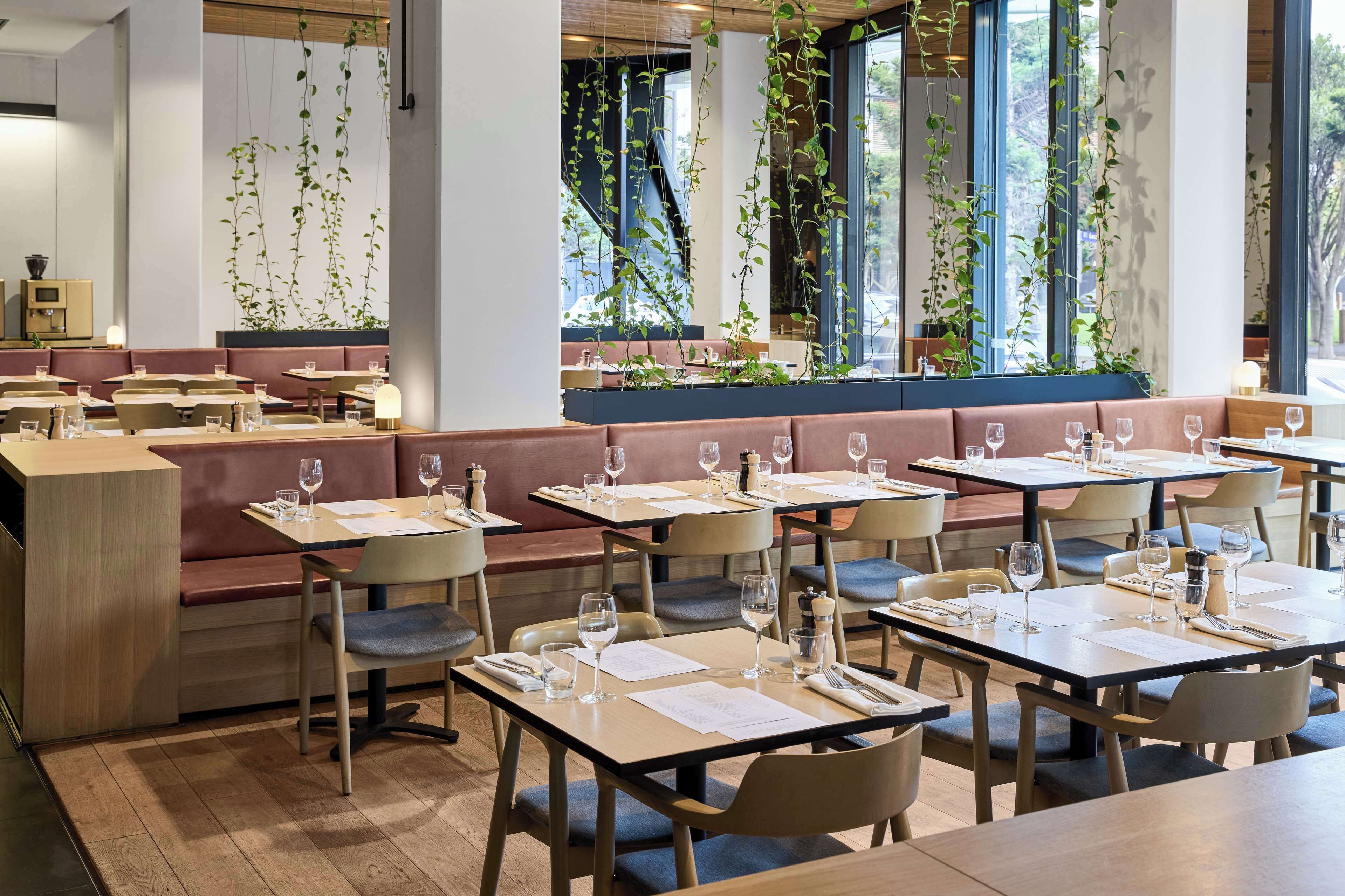 A restaurant with booths and tables, some with wine glasses and menus.