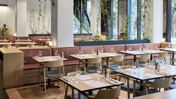A restaurant with booths and tables, some with wine glasses and menus.