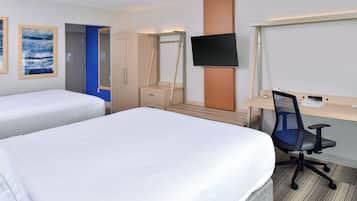 A hotel room with two beds, a desk with a chair, a TV, and a wardrobe.