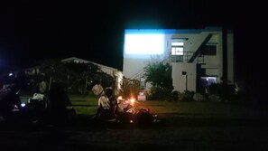 A building with a modern architectural style, featuring a flat roof and a large illuminated sign. - Hoshisunaso (Yoron)
