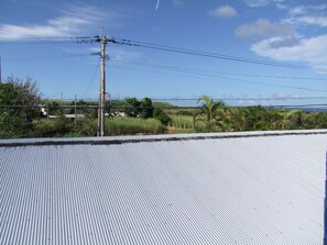 A corrugated metal roof, utility poles, and a clear sky. - Hoshisunaso (Yoron)
