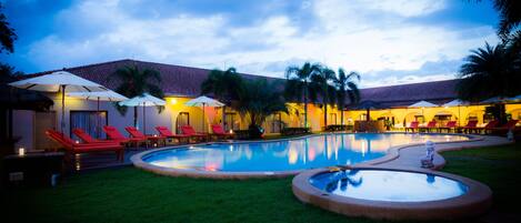 Alberca al aire libre y camastros