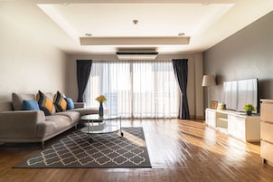 Una sala moderna con un sofá, una mesa de centro y un televisor sobre un mueble.