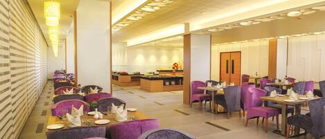 Un espace de restauration moderne avec des chaises et des tables violettes, toutes prêtes pour le repas.